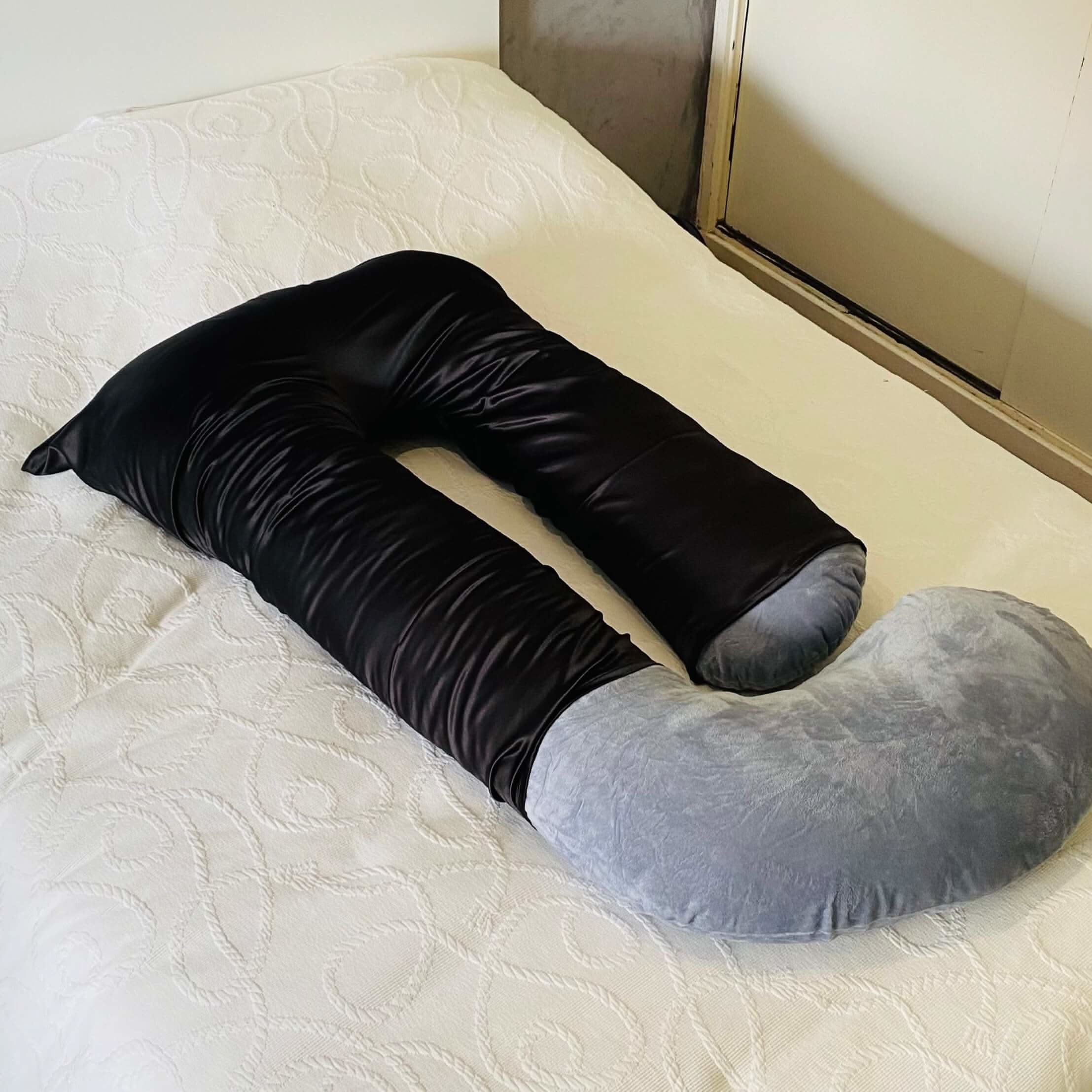 Cooling Silk Cover on the head section of a grey Cuddly Pillow™ on a bed