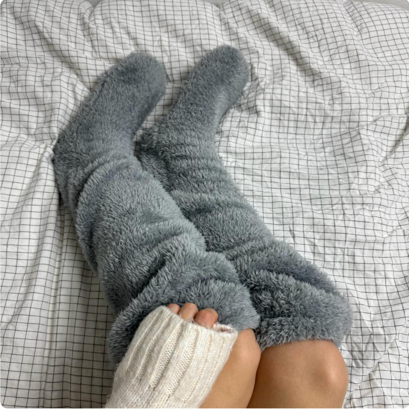 Fuzzy Socks™ by The Snuggles, grey knee-high fluffy socks worn in bed