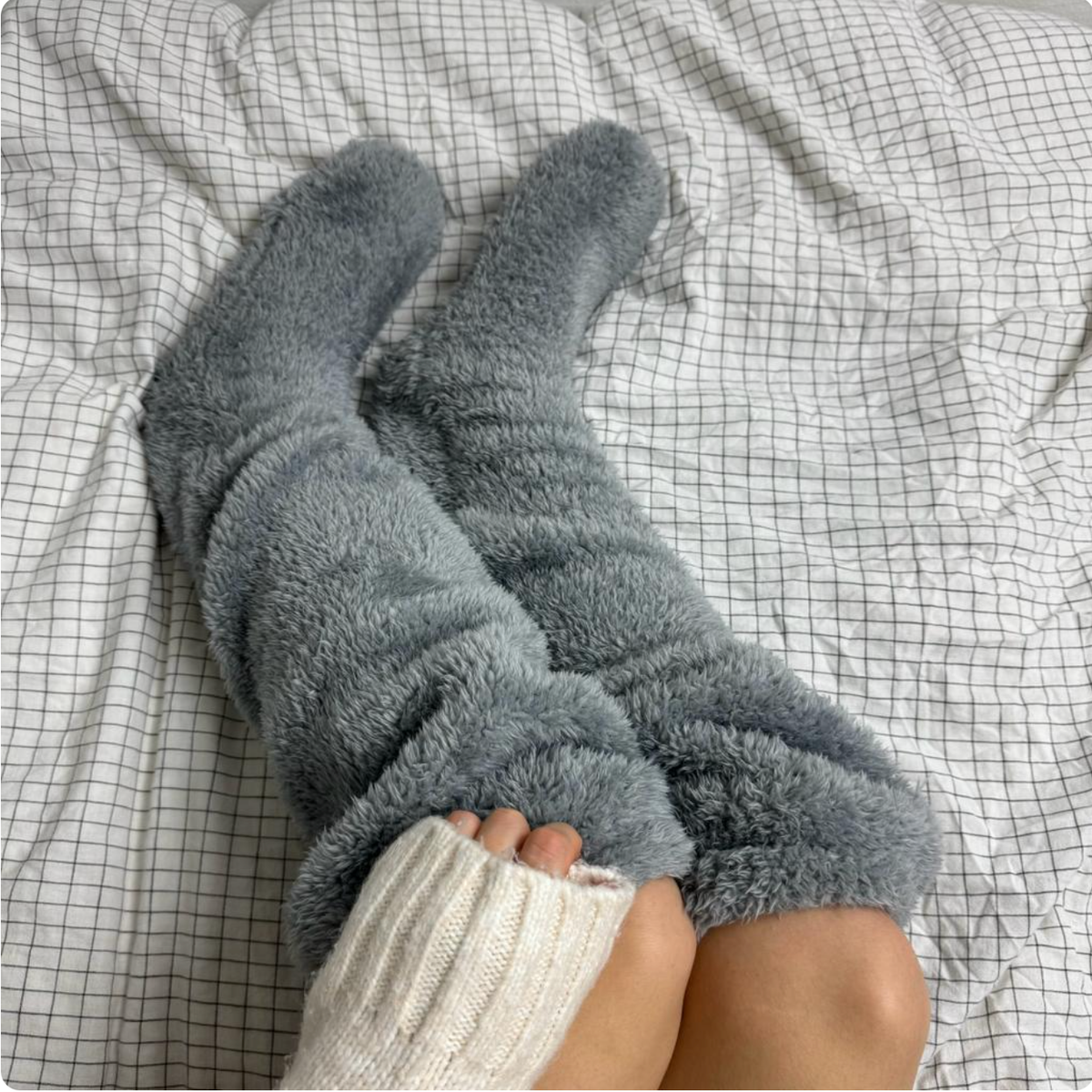 Fuzzy Socks™ by The Snuggles, grey knee-high fluffy socks worn in bed