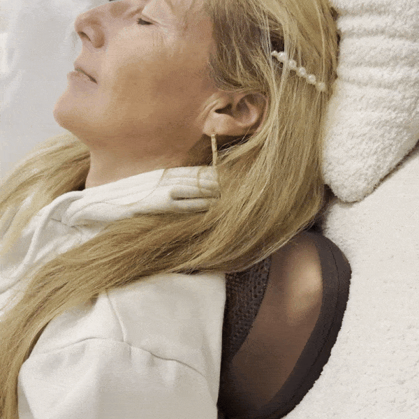 Woman relaxing with the Neck & Back Massager behind her neck