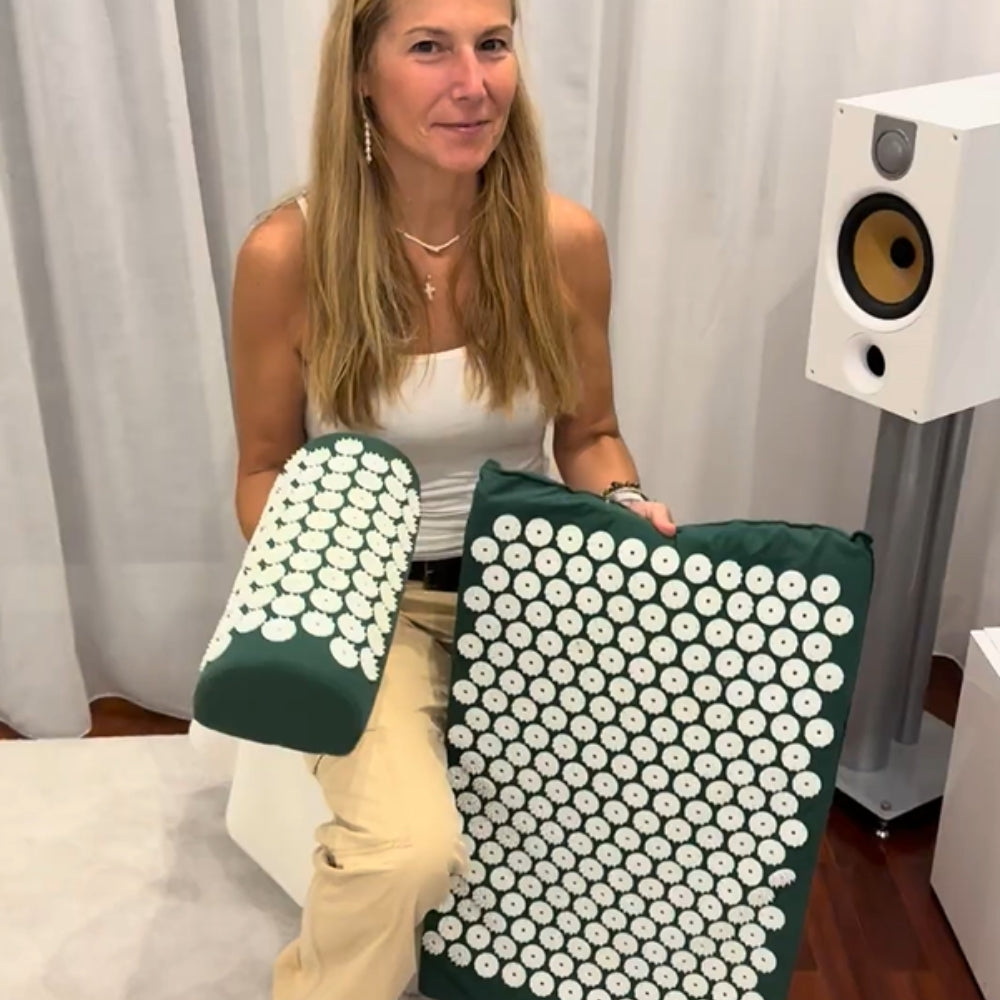 Woman holding the Tension Relief Mat and acupressure pillow