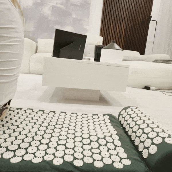 Green Tension Relief Mat and pillow on a living room floor