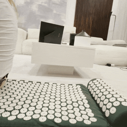 Green Tension Relief Mat and pillow on a living room floor